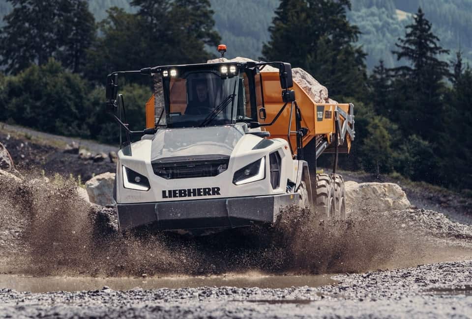 Liebherr ta 230 articulated dump truck hauling material on a rugged job site, showcasing its off-road capability.