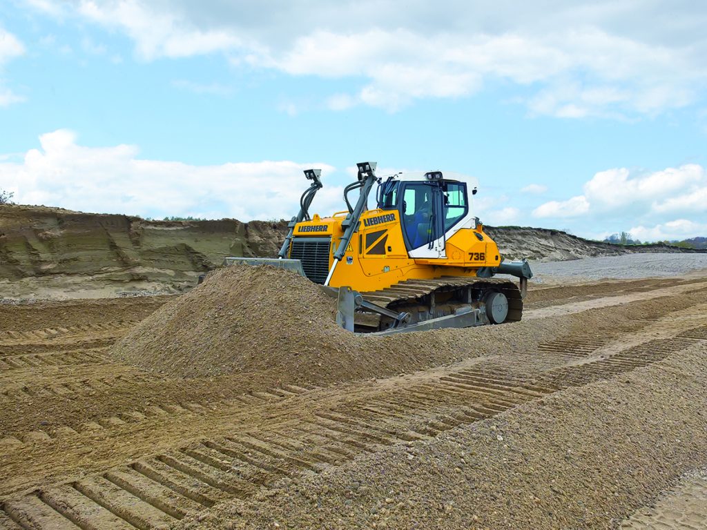 Liebherr PR736 dozer working in a dirt lot with blue sky.